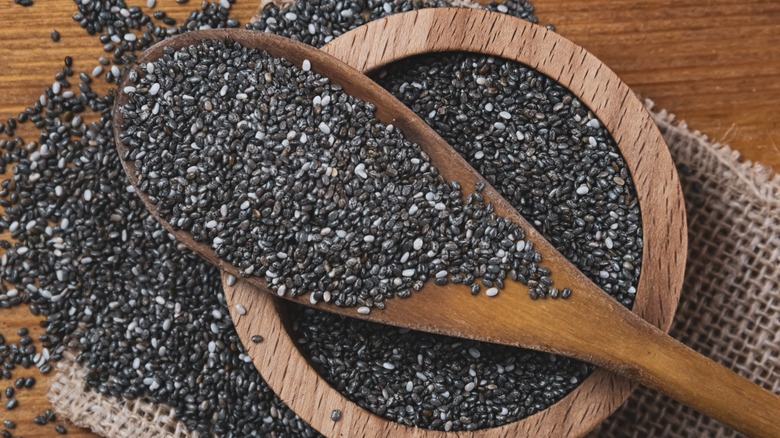 black chia seeds on wooden spoon