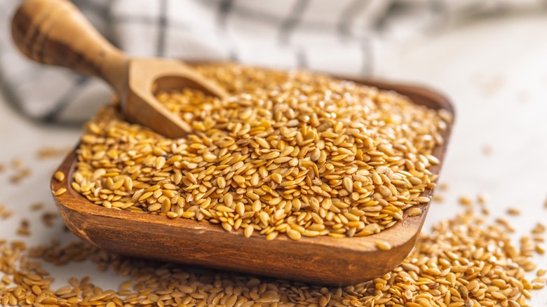 golden flaxseeds with a wooden spoon