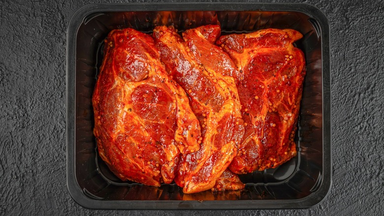 marinating steaks in black plastic tray