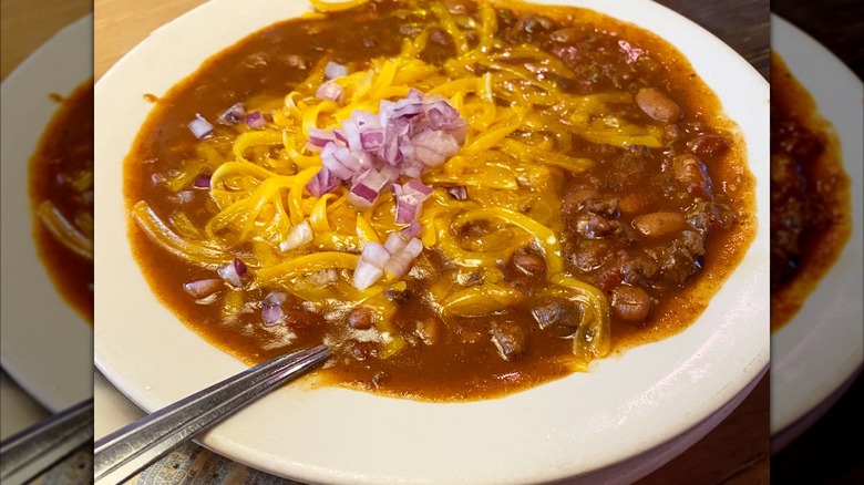 bowl of chili with onions and cheese