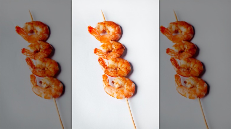 four shrimp on a bamboo skewer