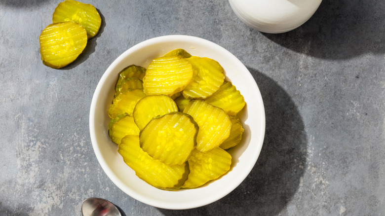 pickle chips in white bowl on slate surface