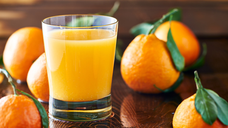 A glass of orange juice on a wooden table