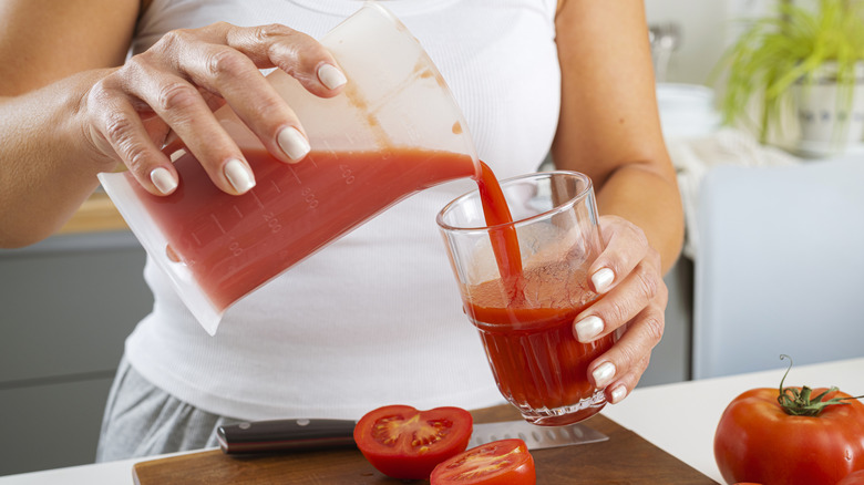 Woman pouring a glass of tomato juice