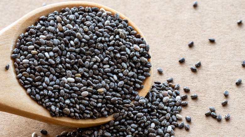 Chia seeds spilling from wooden spoon