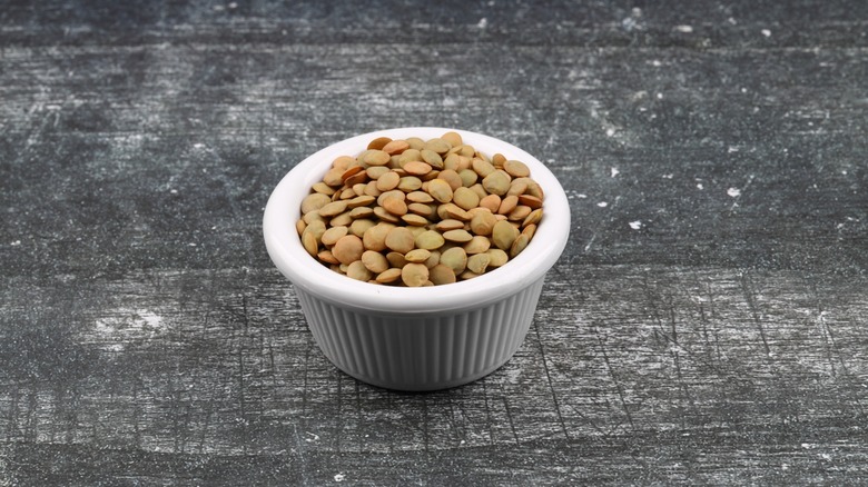 green lentils in ceramic ramekin on black surface