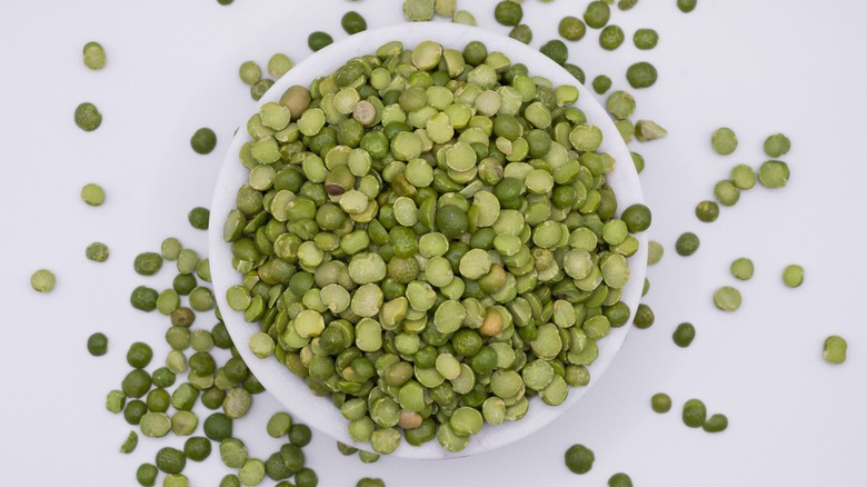 white bowl of split peas on white background