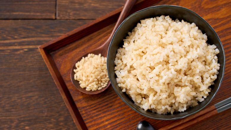 cooked brown rice with wooden spoon