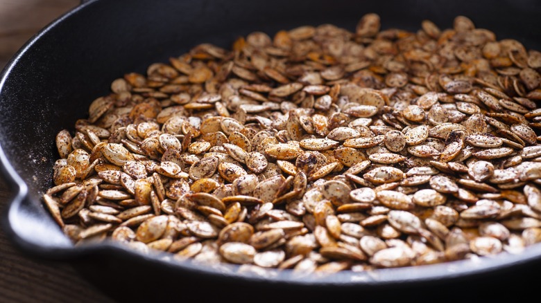 seasoned pumpkin seeds in a roasting pan