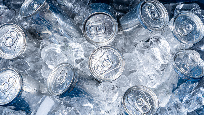 Silver cans in an ice-filled cooler