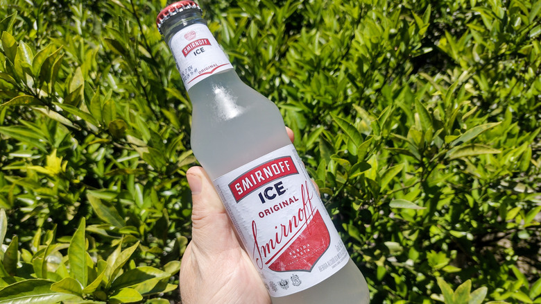 Someone holding a bottle of Smirnoff Ice