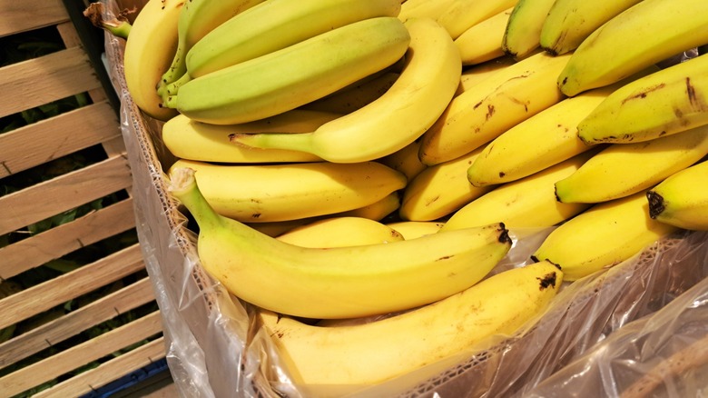 yellow bananas fill a cardboard box