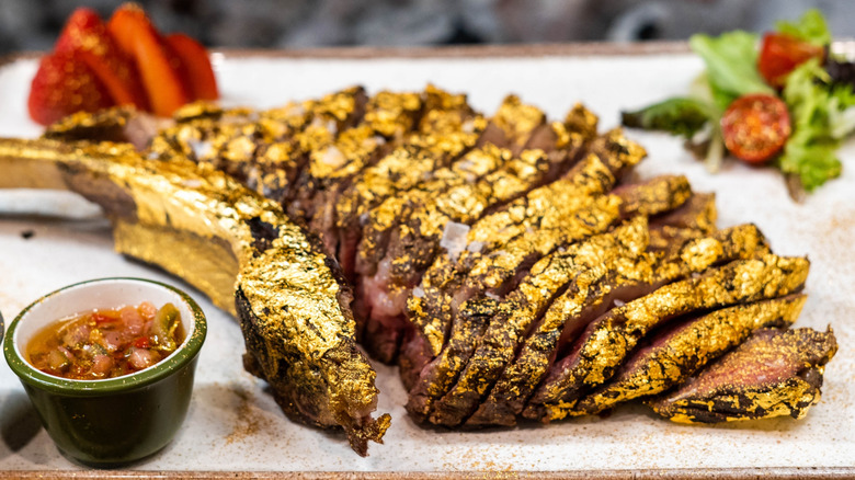 Premium beef tomahawk coated in edible gold