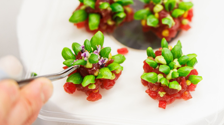 Microgreens on a red diced vegetable dish