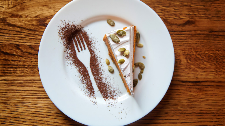 Dessert on a white plate with a cocoa powder fork design