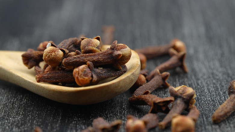 whole cloves on a wooden spoon