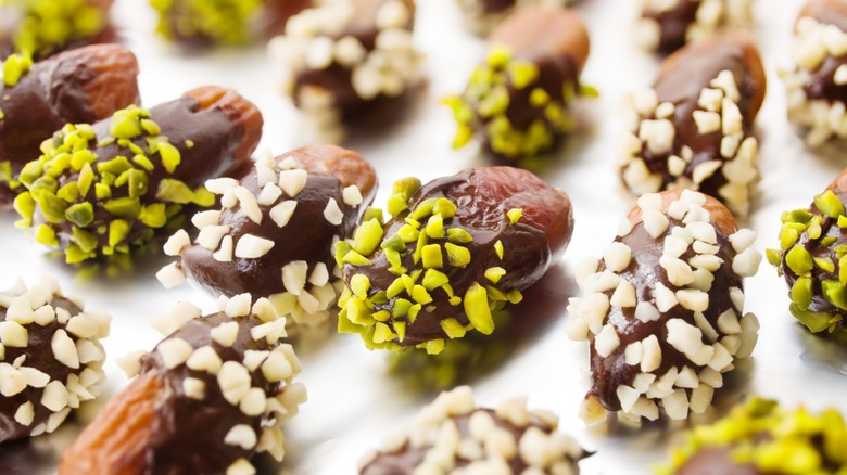 chocolate-covered dates with crushed nuts on tray