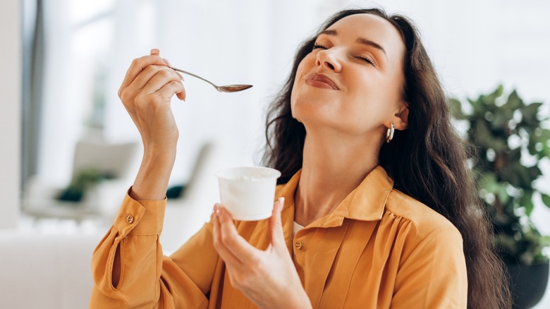 happy woman enjoys a small dessert in a cup