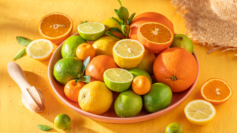 Oranges, lemons, and limes on a bowl