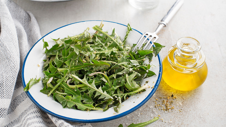 Plate of dandelion salad dressed with oil, vinegar, and spices