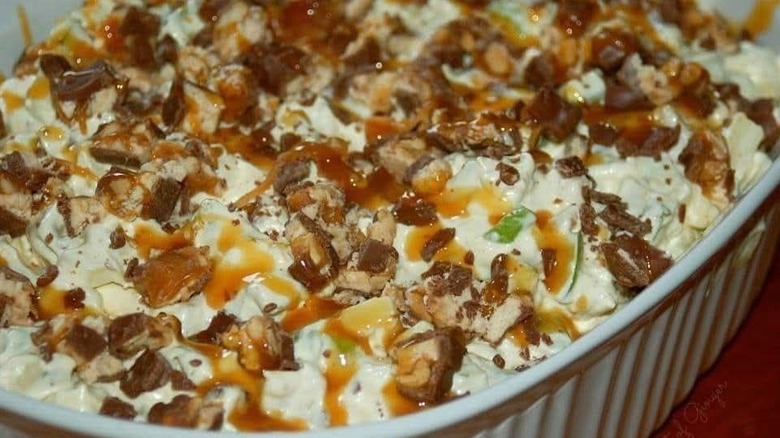 Dessert salad with Snickers bars, caramel sauce, Cool Whip, and green apples