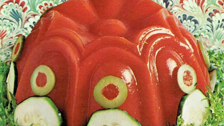 Molded tomato aspic garnished with green olives and cucumbers