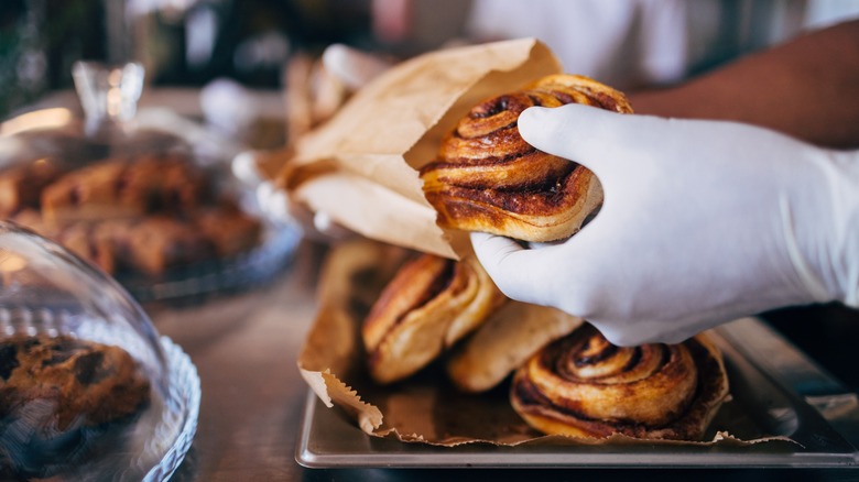 putting a cinnamon roll in a bag