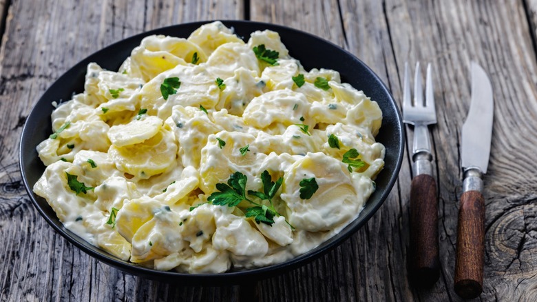 potato salad in bowl with utensils