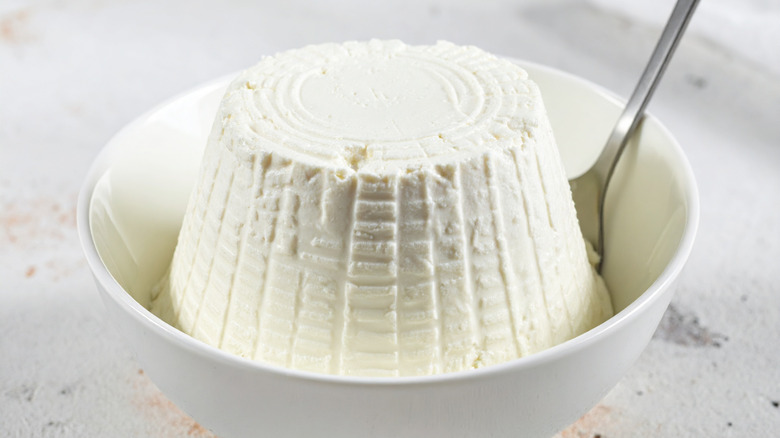 Fresh ricotta cheese in white bowl