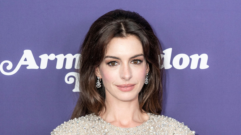 anne hathaway in 2022 with purple background