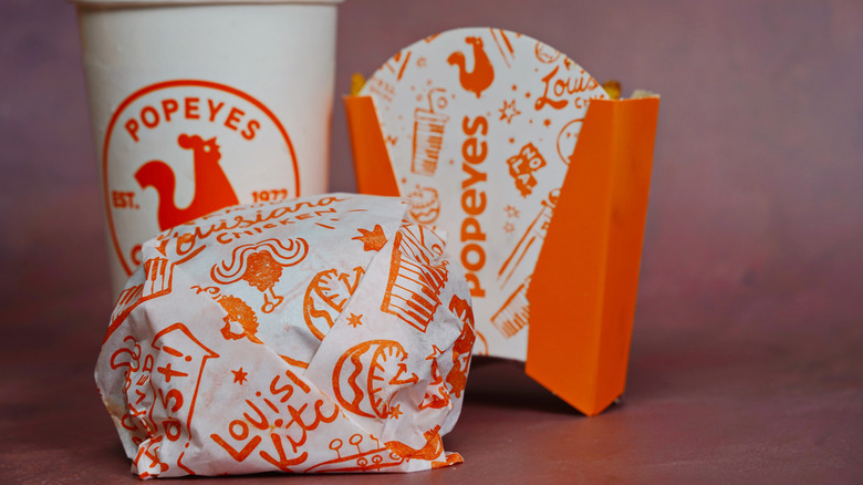 Popeyes chicken cup and food containers, closeup.