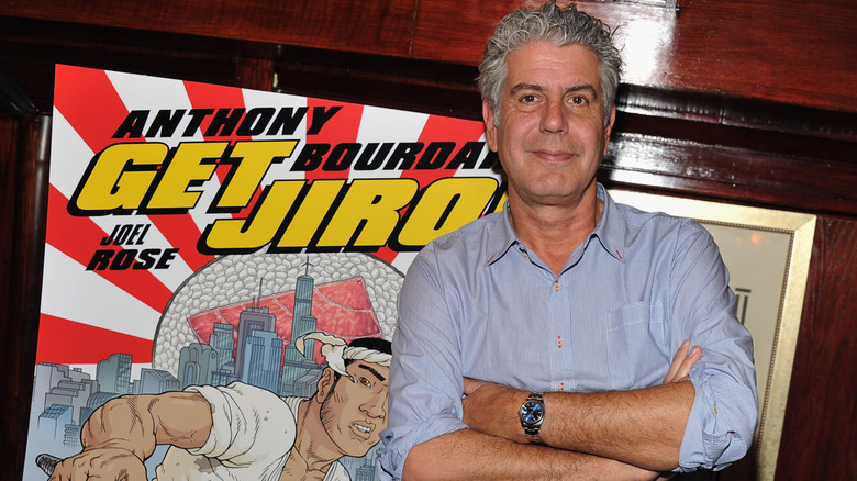 Anthony Bourdain poses in front of his comic book