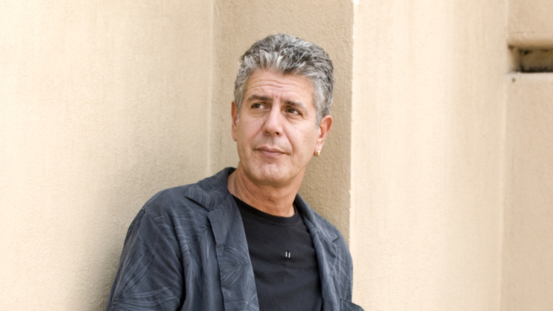 Anthony Bourdain stands against wall in the Liberdade area of Sao Paulo, Brazil