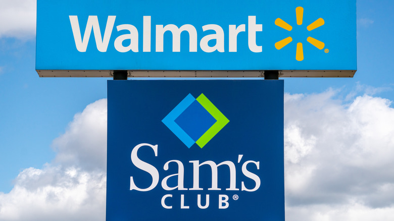 Walmart and Sam's Club signs against blue sky.
