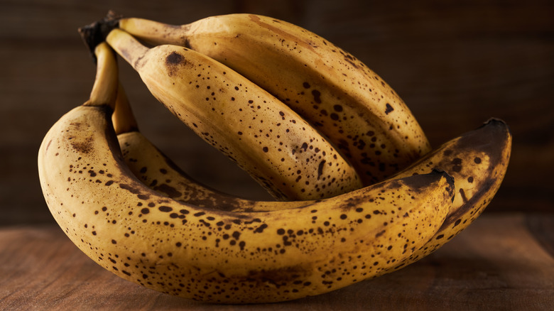 Overripe bananas on wooden board.