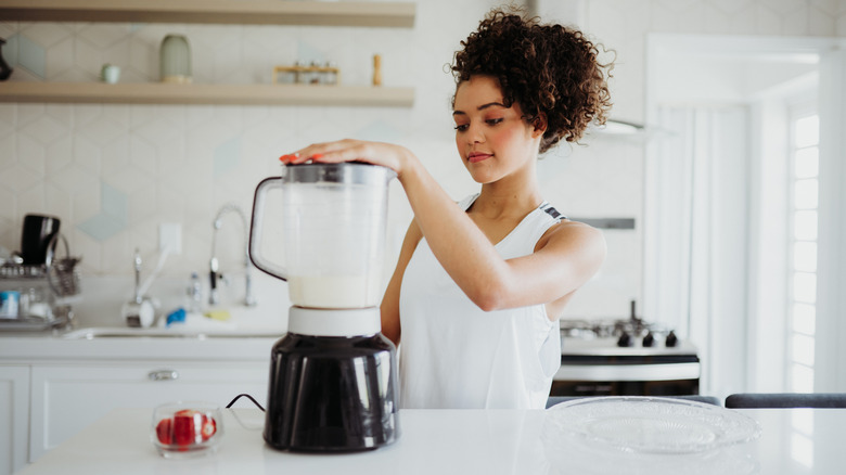 Woman using an electric blender