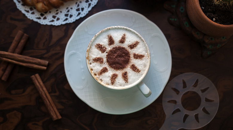 Sun design made of cinnamon powder on a cappuccino