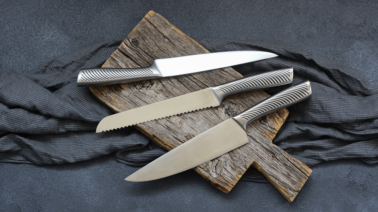 Three kitchen knives on dark background