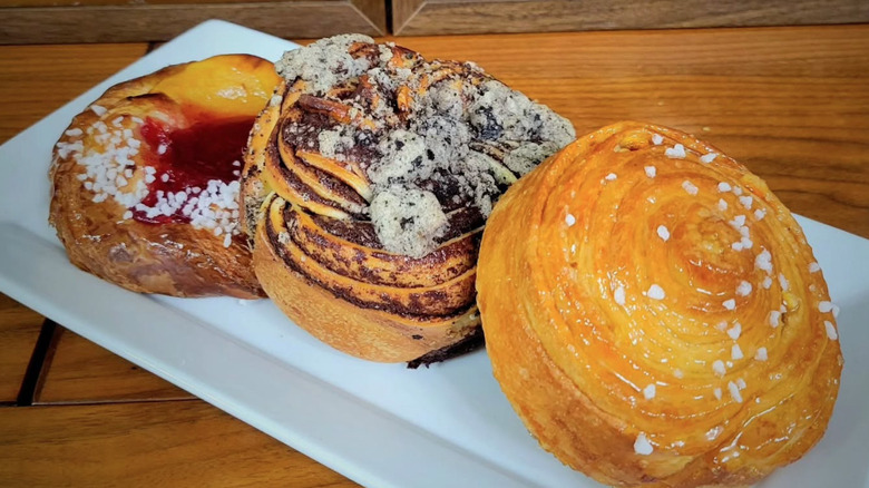 Three laminated pastries on a plate on a wooden table