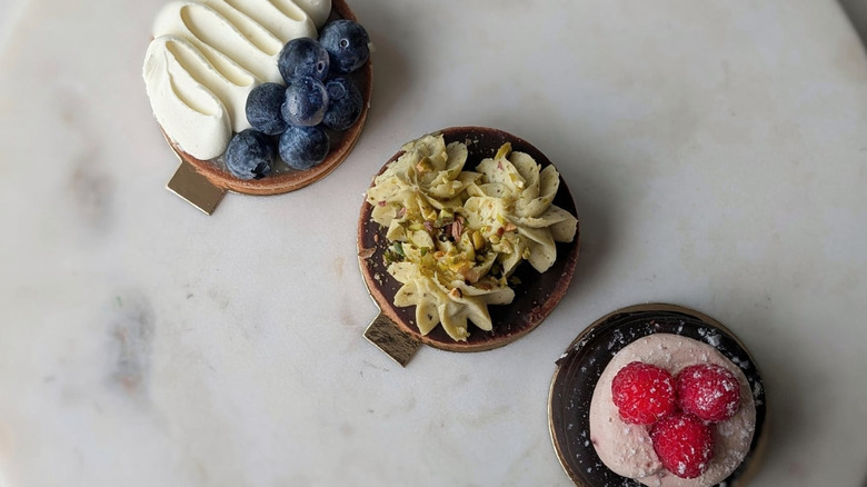 White marble circular serving tray with three French pastries, overhead view