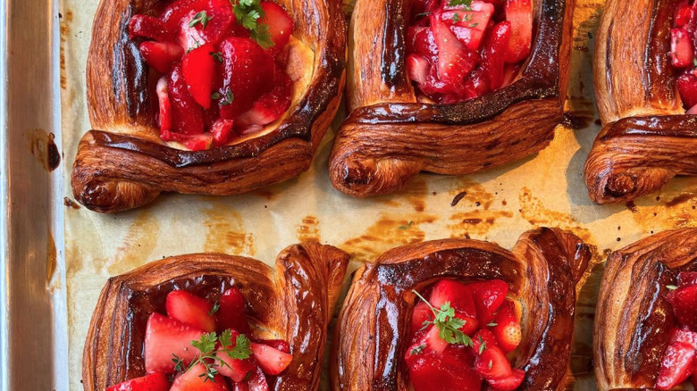 Baking sheet with danishes filled with fresh strawberries