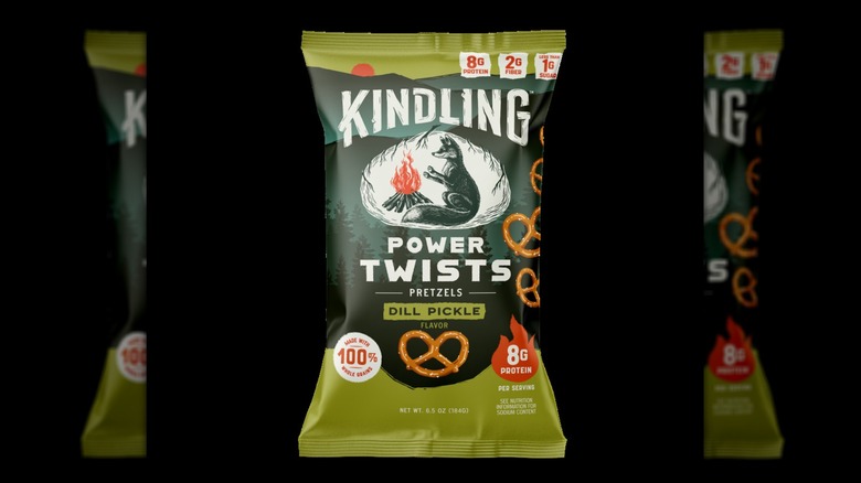 A bag of Kindling™ Dill Pickle Power Twists Pretzels on a black background