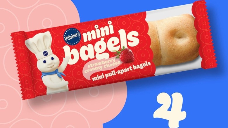 One of four individually wrapped mini pull-apart bagels with strawberry cream cheese in a red package on a blue and pink background