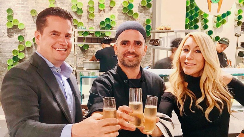 Matt Higgins, Guy Vaknin, and Lori Greiner clinking glasses in restaurant