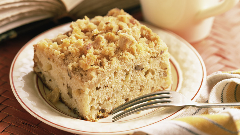 Slice of coffee cake on white plate with fork.