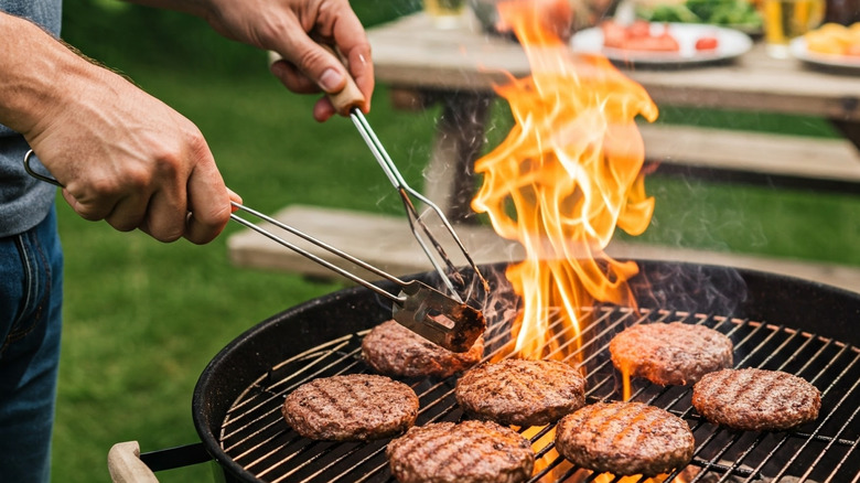 Burgers being grilled on a charcoal grill.