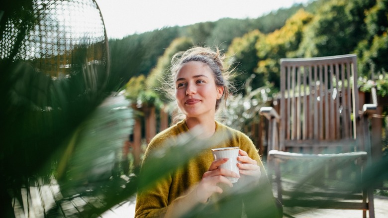 a woman enjoys a mug of outdoor tea