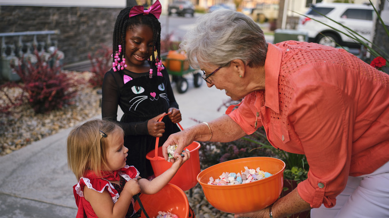 Boomer woman handing out Halloween candy