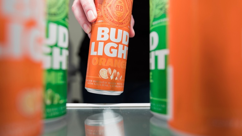 hand removing a bud light peels from the fridge