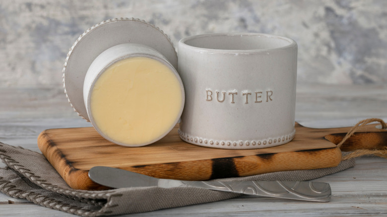 Vintage butter bell and silver knife on wood cutting board
